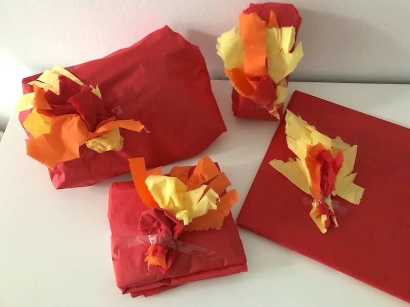 Geschenke zum Feuerwehr-Geburtstag, eingepackt in rotes Seidenpapier und Flammen | Mehr Infos zu unserer Deko, Spielen und dem Essen zur Feuerwehrparty auf Mamaskind.de