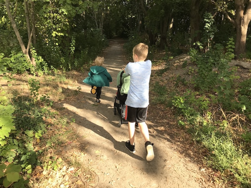 Zwei Jungs rennen in den Wald - mit Püppiline im Wagen. | Mehr Infos auf Mamaskind.de