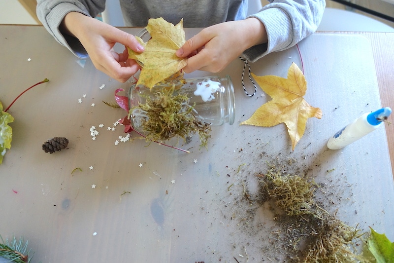 Natur pur: der 4-Jährige beklebt mit viel Leim ein Glas. Das wird ein hübsches Windlicht für unseren Herbsttisch! | Mehr Infos auf Mamaskind.de