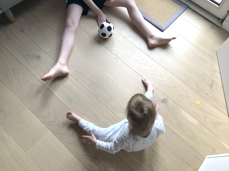 Zwei Kinder spielen mit dem Ball.