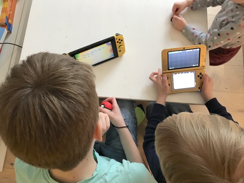 Die Kinder spielen friedlich nebeneinander: einer Pokémon Let's go! auf der Switch, der andere Kirby auf dem 3DS XL. | Mehr Infos zu den coolsten Nintendo Switch Spielen für Kinder auf Mamaskind.de