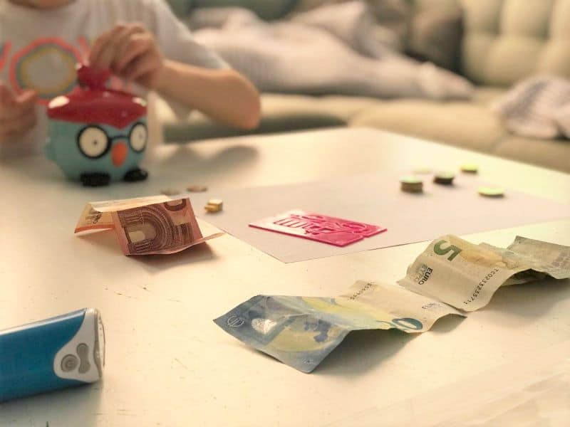 Ein Kind ist reich und zählt sein Taschen- und Geburtstagsgeld.