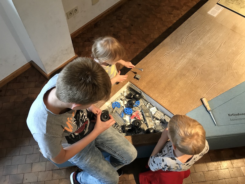 Die drei Kinder spielen mit dem Baukasten im Technikmuseum Berlin. - Mamaskind.de