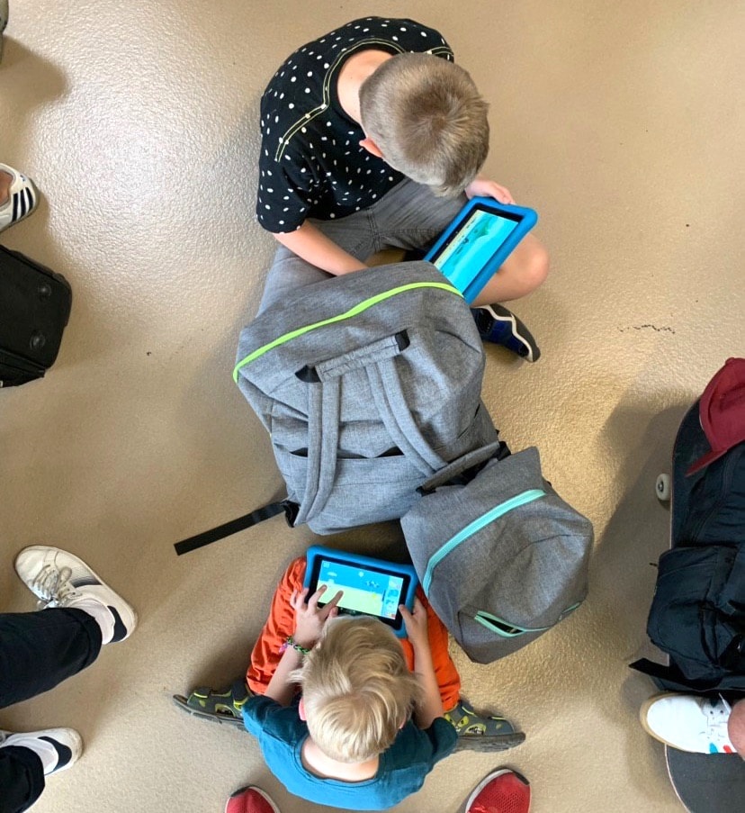 Kinder spielen Tablet am Flughafen. Der Flug verzögert sich. - Mit Kindern nach Mallorca auf Mamaskind.de