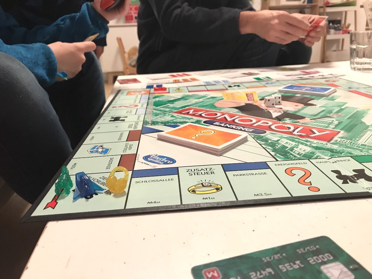 Die Kinder spielen mit den Freunden Monopoly Banking. - Mamaskind.de